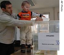 An ethnic Albanian man casts his ballot with his son at a polling station in Presevo, 21 Jan 2007