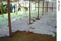 Covered bodies are laid out as Tutsi refugees from Congo, who survived a massacre by Hutu extremists at UN-run camp in Gatumba, Burundi, began the grim task <br/>(File photo - 15 Aug 2004)