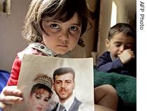 Palestinian girl, shows wedding picture of her father Adnan Abdullah at her apartment at Baghdad's eastern Baladiat district, after arrest of her father and uncles by Iraqi police (File photo - 26 March 2006)  