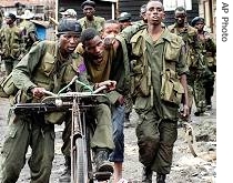 Congolese army soldiers use a bicycle to transport a wounded soldier after battles with a local warlord (File photo - 28 Nov 2006)  