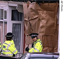 British police officers stand outside a house in Birmingham, England where police arrested suspected terrorists, 31 Jan 2007
