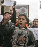 Palestinian holds a poster of the late Palestinian leader Yasser Arafat during a rally calling for an end to the internal fighting, in the West Bank city of Hebron, 3 Feb 2007
