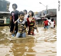 Indonesians walk through their flooded neighborhood in Jakarta, 5 Feb 2007