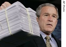 President Bush holds up a pile of earmarks as he speaks about the economy at Micron Technology