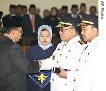 Newly-elected Governor of Aceh Irwandi Yusuf, second from right, and his deputy Muhammad Nazar, right, are congratulated by officials after their swearing- in ceremony in Banda Aceh, 8 Feb 8 2007