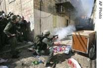 An Israeli police officer, right, calls for reinforcements during clashes with Palestinian stone throwers in the narrow alleyways of east Jerusalem's Old City, 9 Feb 2007