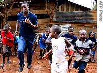 Multiple gold medalist and track legend, Michael Johnson, runs with children in Nakulabye, a suburbs in Ugandan capital Kampala (File)