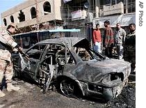 Iraqi army soldier inspects a car destroyed in a car bomb explosion in central Baghdad, 11 Feb 2007