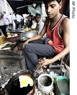 Indian roadside food stall worker fries an egg in Kolkata, 14 Oct 2006