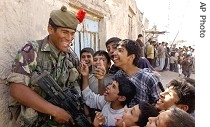 Private Matereti Vere, 25, originally from Fiji and serving with 1st Battalion of The Black Watch, left, shares a laugh with Iraqi children in Zubayr, southern Iraq