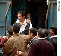 Abdel Karim Suleiman (in white jacket) is escorted by police from a police van to a court in Alexandria (22 Feb 2007)