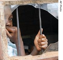 An unidentified girl looks from a broken window at the Just Children Foundation for orphans in Harare (File)  