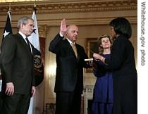 President George W. Bush looks on as Secretary of State Condoleezza Rice administers the oath of office to Deputy Secretary of State John Negroponte