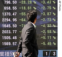 A man looks at a stock indicator showing down arrows in Tokyo, 28 Feb 2007