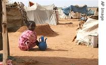Young girl washes plates for her family in North Darfur refugee camp of El Sallam
