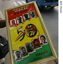 A street vendor walks with a placard featuring Ghanean statesmen on the streets of the capital city Accra ahead of the country's 50th Independence Anniversary celebrations