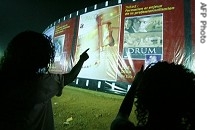 People look at FESPACO festival movie posters, 28 Feb. 2007