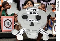 Protesters hold slogans during a rally against the newly signed anti-terrorism law in Manila on Tuesday 6 March 2007