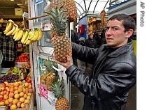 Azerbaijani Eldar Khuseinov shows pineapples on sale at a market in Moscow