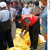 A police officer checks the bodies of victims that were killed in Garuda plane crash, in Yogyakarta, 07 Mar 2007