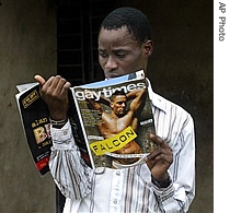 Gay activist Bisi Alimi, 27, looks at a copy of Gay Times magazine in front of his house in Lagos, Nigeria, 11 Oct 2006