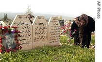 Kurdish woman places flowers at graves of her loved ones in Halabja, 16 Mar. 2007