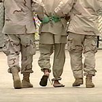 A detainee at Guantanamo Bay, Cuba being escorted by two U.S. soldiers