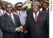 Ivory Coast's outgoing prime minister Charles Konan Banny (r) shakes hands with his successor former rebel leader Guillaume Soro following the hand-over ceremony in Abidjan, 04 Apr 2007