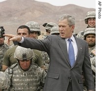 President Bush gestures while posing for photos with troops during his visit to the National Training Center at Fort Irwin, California