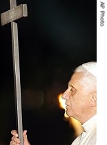 Pope Benedict XVI holds the wooden cross next to a torch, during the Via Crucis torchlight procession on Good Friday in front of the Colosseum in Rome, 6 Apr 2007