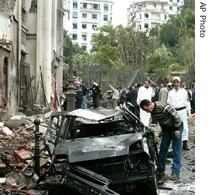 Residents look at the wreckage of a car after a bomb exploded near the prime minister's office in Algiers, 11 Apr 2007