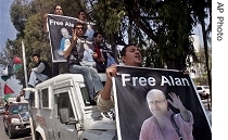 Palestinian journalists hold posters of BBC correspondent Alan Johnston, during a car demonstration calling for his release in Gaza City, Thursday, 12 April 2007