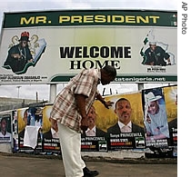 A Nigerian man look at election posters in Port Harcourt, Nigeria, 15 Apr 2007