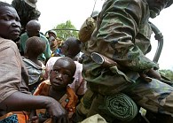 Villagers sit in the back of a Ugandan army truck as they are moved to a safe area