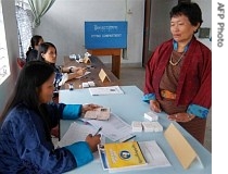 A Bhutanese election official checks the citizenship card of a Bhutanese woman at a voting center during 
