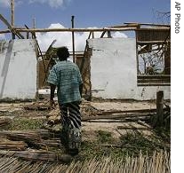 Simone Chivale, 30, walks towards a destroyed home, in the Mozambique coastal town of Vilankulo, 24 Apr 2007
