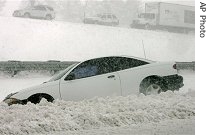 A motorist sits in his stuck Chevrolet Cavalier after spinning out on Interstate 25 and ending up in the median near Monument, Colorado, 24 Apr 2007