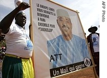 A supporter holds a poster of the President of Mali Amadou Toumani Toure during a campaign meeting in Fana, 150km east of Bamako, 25 Apr 2007