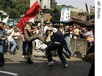 Protesters fight with police officers during the demonstration in downtown Macau 1 May 2007