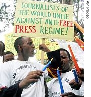 Ethiopian journalists hold placards and lighted candles as they shout slogans during a demonstration at the Ethiopian Embassy in Nairobi, 2 May 2006