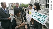 Climate Change conference delegates walk past protesters in front of United Nations office in Bangkok, 30 Apr 2007