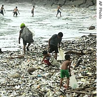 Scavengers collect items that can be recycled from a pile of garbage washed ashore at Manila's bay following days of torrential rains (File)