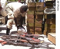 A government soldier inspects weapons handed over by members of the business community, 3 May 2007