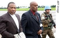 Former Liberian President Charles Taylor (L) is escorted by UN officials