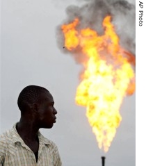 A resident of Nigeria's oil-rich delta region looks at flames from an oil company's gas flare. The region is beset by kidnappings and sabotage.