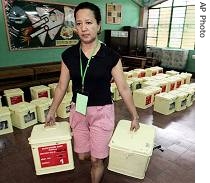 Filipino woman carries ballot boxes as they prepare election paraphernalia at a distribution center in suburban Manila, 13 May 2007
