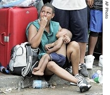 A woman and her child wait with hundreds of other flood survivors at the Convention Center in New Orleans  (file photo)
