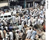 Pakistani volunteers, security officials gather at the suicide bombing site in Peshawar, 15 May 2007