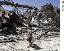 A Palestinian youth walks past the rubble of a destroyed metal workshop allegedly used by the Islamic group Hamas after it was hit by an Israeli missile strike in Gaza City, 19 May 2007