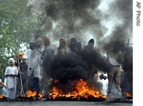 Protesters burn tires during a strike in the outskirts of Jammu, India, 22 May 2007